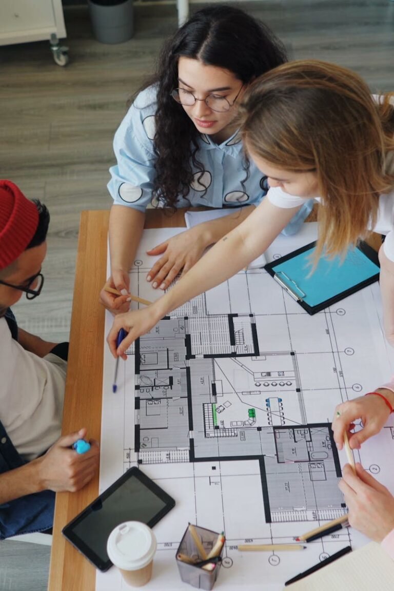 Young creative professionals discussing an architectural blueprint in a modern office setting.